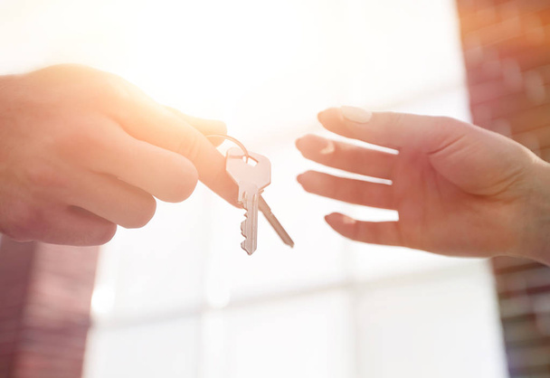 Обрезанный образ агента по недвижимости, дающего ключи от дома человеку в офисе - Фото, изображение