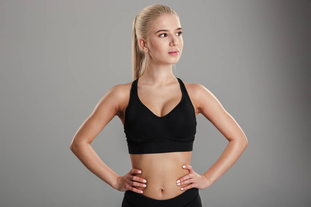 Amazing young blonde sports lady standing isolated - Fotografie, Obrázek
