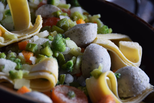 frozen tagliatelle pasta with vegetables in a pan - 写真・画像