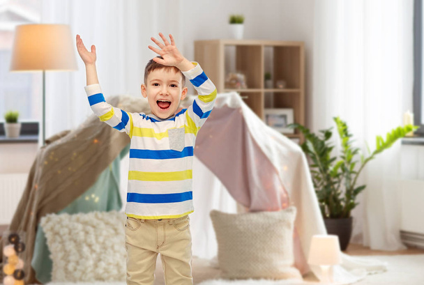happy little boy waving hands at home - Фото, изображение