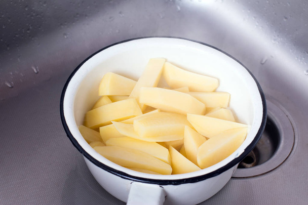 Abtropfen von gekochten Kartoffelscheiben im Sieb - Foto, Bild