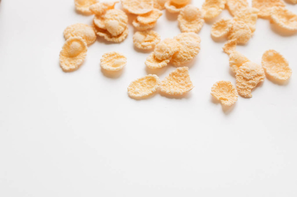 delicious crispy cornflakes scattered on white background,  healthy breakfast - Fotografie, Obrázek