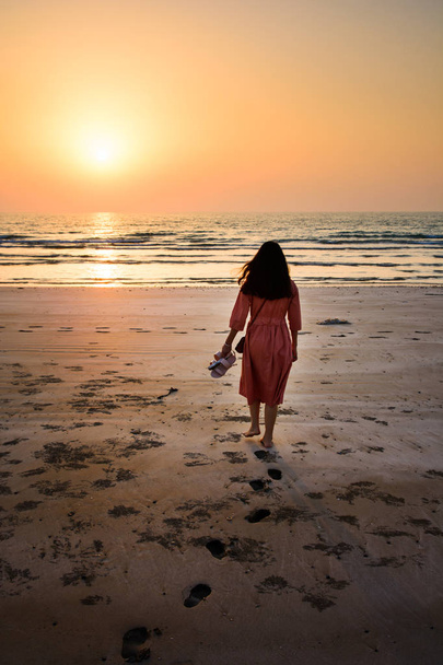 Chica caminando en la playa al atardecer - Foto, Imagen