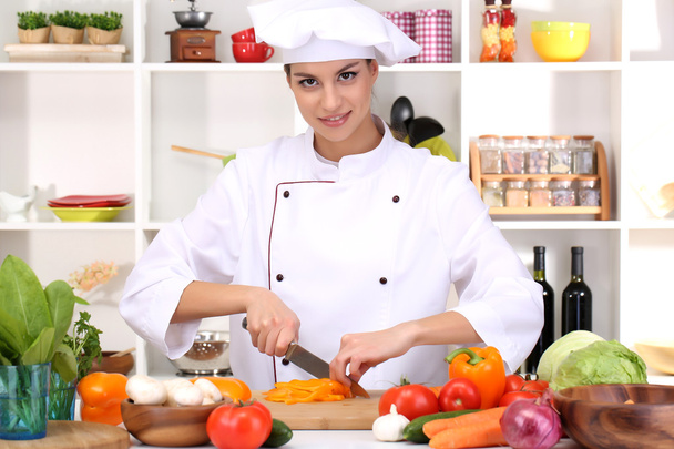 Young woman chef cooking in kitchen - Foto, Bild