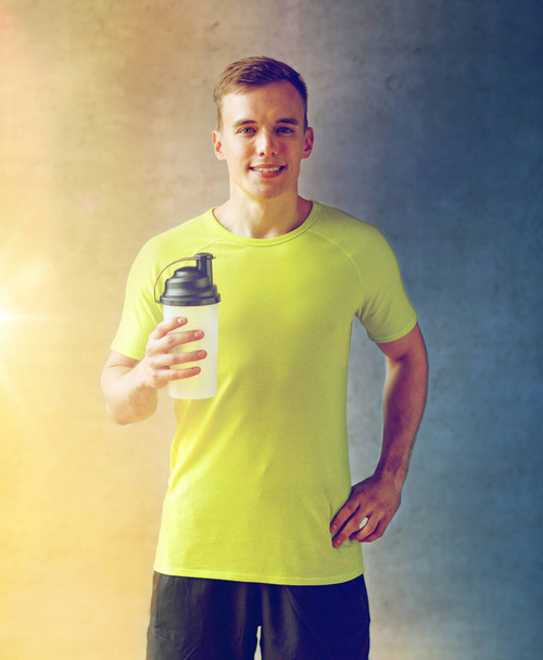 smiling man with protein shake bottle - Foto, immagini