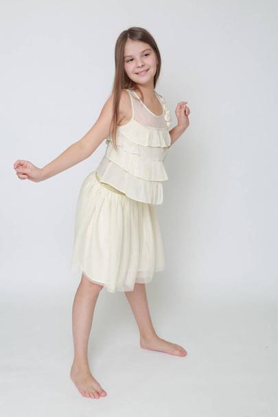 Studio image of happy emotional caucasian little girl moving and dancing - Fotó, kép