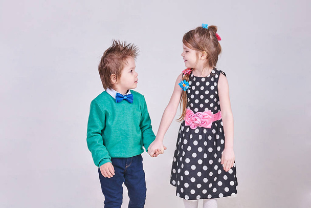 Güzel küçük erkek ve kız, el ele tutuşup birbirlerine bakıyorlar - Fotoğraf, Görsel