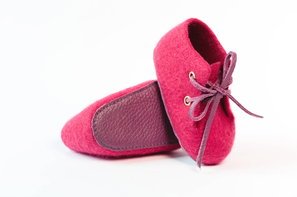 Różowy baby ręcznie robione buty wykonane z wełny merino na białym tle. - Zdjęcie, obraz