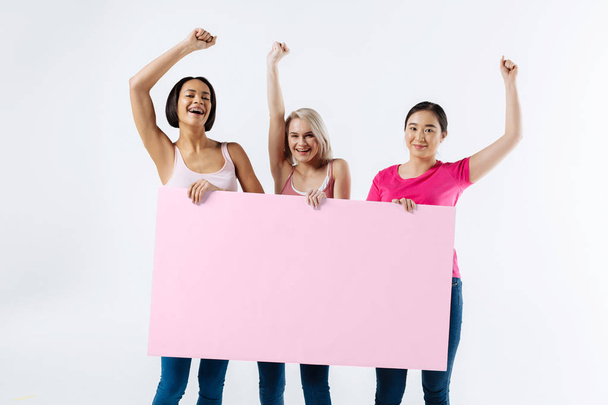 Nice good looking women holding a poster - Photo, Image