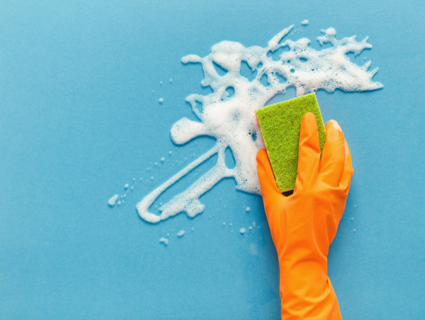Hand in de handschoen wassen glasoppervlak met spons en schoonmaken van schuim - Foto, afbeelding
