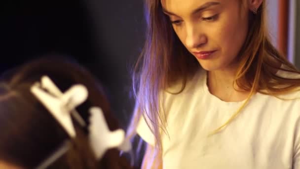 young hair stylist make hairstyle with beautiful woman - Záběry, video