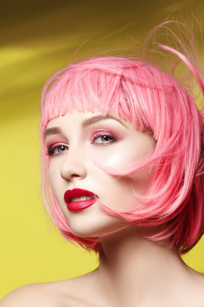 Молодая женщина в розовом парике. Красивая модель с макияжем. Яркий весенний вид. Сексуальный цвет волос, средняя прическа
 - Фото, изображение