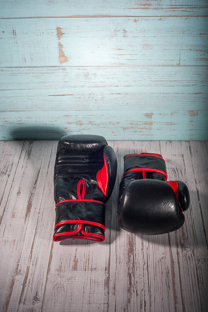 Boxing gloves on blue and white cracked wooden background - Foto, afbeelding