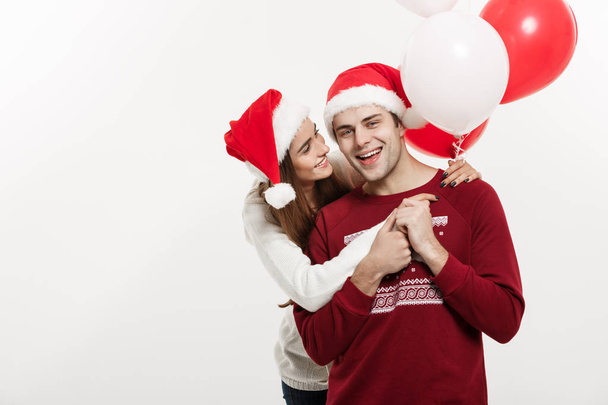 Christmas Concept - Nuori tyttöystävä tilalla ilmapallo halailee ja leikkii poikaystävänsä kanssa tekee yllätys jouluna
 - Valokuva, kuva