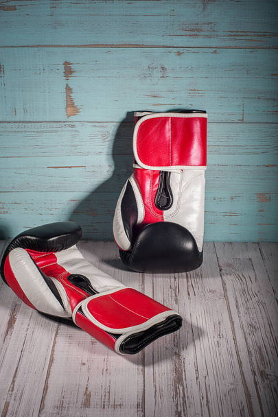 Boxing gloves on blue and white cracked wooden background - Фото, изображение