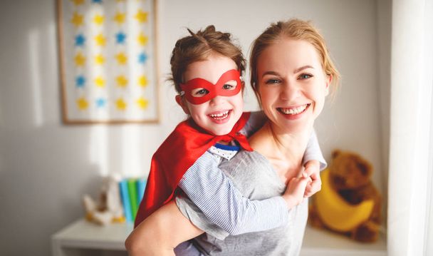 child girl in a super hero costume with mask and red cloak  - Foto, Imagem