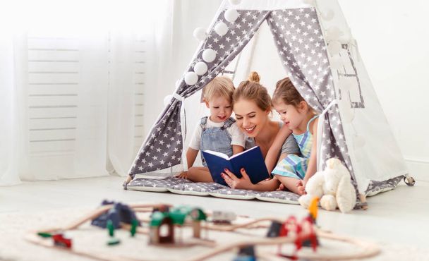 family mother reading to children book in tent at hom - Foto, Imagem