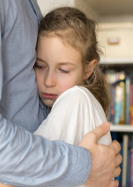 Sad little girl hugging her dad. - Фото, зображення