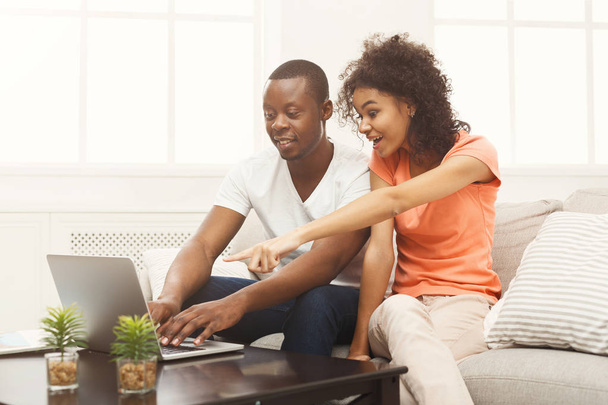Joven pareja afroamericana trabajando en laptop
 - Foto, Imagen