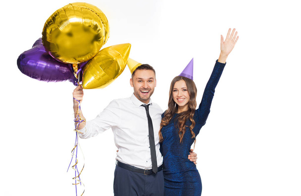 happy couple with party caps and balloons - Фото, изображение