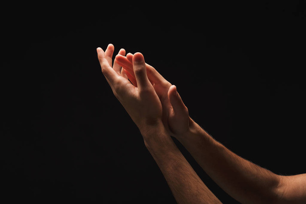 Homme tenant les mains en forme de coupe, découpe sur noir
 - Photo, image