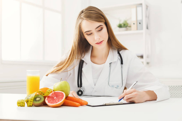 Nutritionist desk with fruit and measuring tape - Foto, afbeelding
