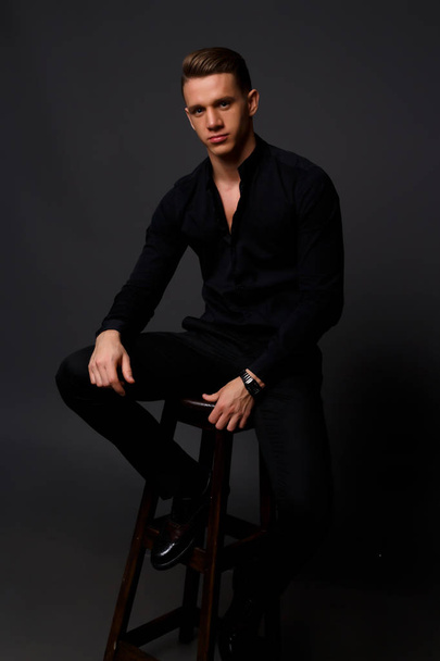 the man is sitting on a dark background - Photo, image