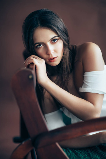 Fashion portrait of young woman on brown background - Fotó, kép