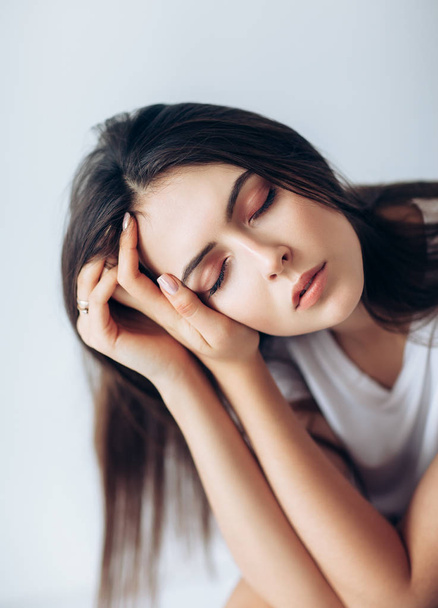 portrait of young woman with closed eyes and hands touching her face - Fotoğraf, Görsel