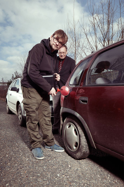 Driver filling empty tank with colleagues gasoline from reserve canister - Zdjęcie, obraz