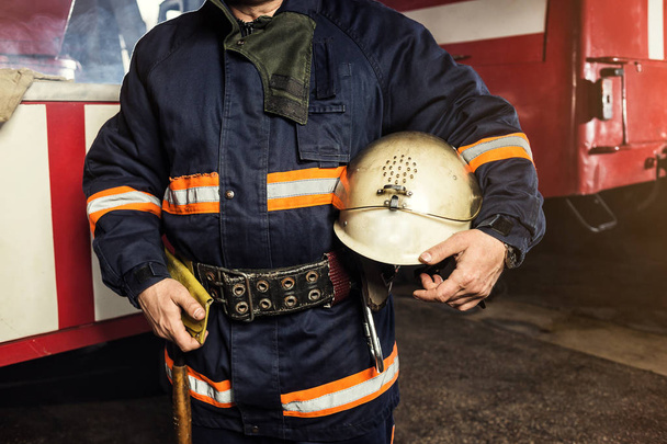 Feuerwehrmann im Einsatz in der Nähe eines Feuerwehrfahrzeugs. Notsicherung. Schutz, Rettung vor Gefahr. - Foto, Bild