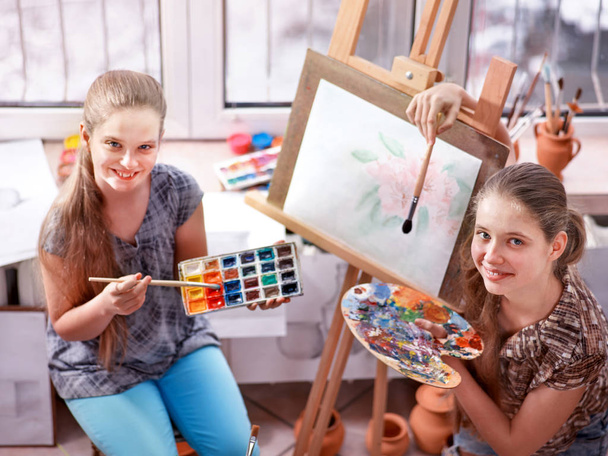 Artist painting on easel in studio. Authentic children paints . - Foto, Imagen