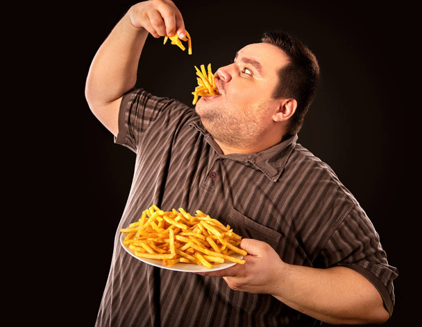 Tlustý muž jíst fast food hranolky pro osoby s nadváhou. - Fotografie, Obrázek