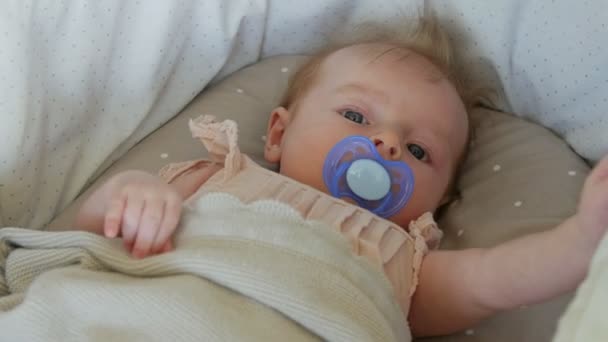 Das drei Monate alte Baby liegt auf einer Decke mit Schnuller. die Babys aus nächster Nähe. - Filmmaterial, Video