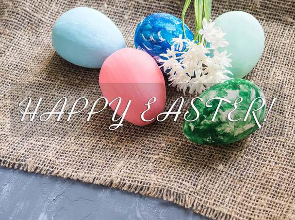 Easter eggs and spring color on a background of burlap added a text of a happy Easter Easter concept - 写真・画像
