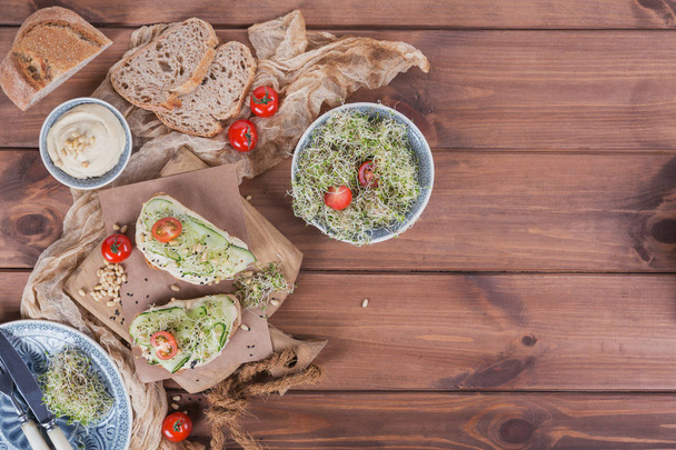 Sağlıklı vejetaryen bruschettas ekmek, mikro Yeşiller, humus, - Fotoğraf, Görsel