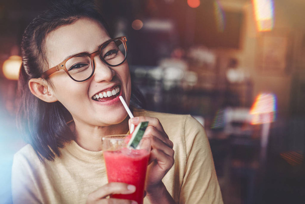 Asian women are drinking watermelon juice smoothie. Happy mood.    Focus on Face - Zdjęcie, obraz