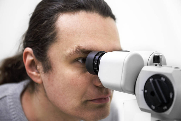 Concetto di optometria. Test medici diagnostici della vista del paziente mediante apparecchiature oftalmologiche in clinica
 - Foto, immagini