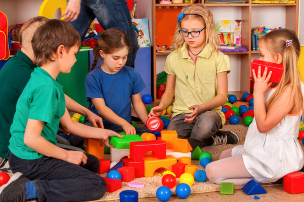 Kinder Bausteine im Kindergarten. Gruppe Kinder spielen Spielzeugboden. - Foto, Bild