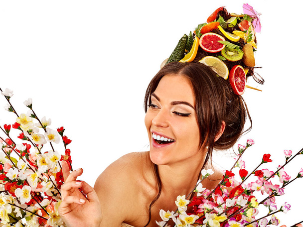 Hiusnaamari tuoreita hedelmiä naisen pään ja kevään kukkia
. - Valokuva, kuva