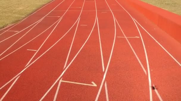 Drone volar sobre rojo pequeño estadio pista de atletismo con línea
 - Metraje, vídeo