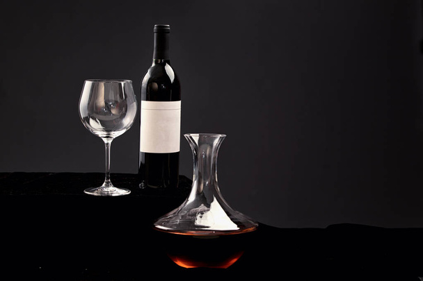 Ízletes vörösbor palack és üveg borral töltött fekete alapon - Fotó, kép