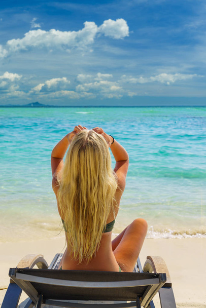beautiful tanned woman with blond hair relaxing on a tropical island with perfect beach. - 写真・画像