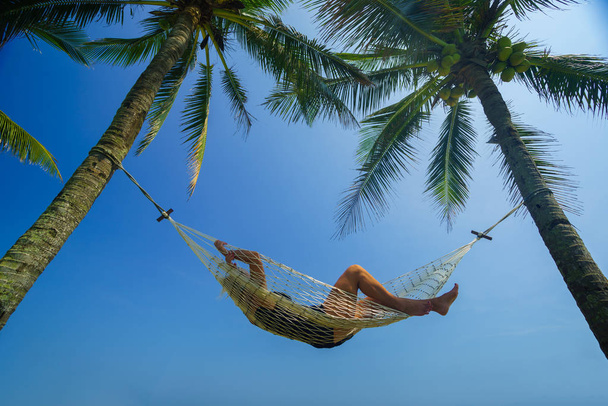Woman relaxing on a hammock at the tropical beach resort - Fotoğraf, Görsel