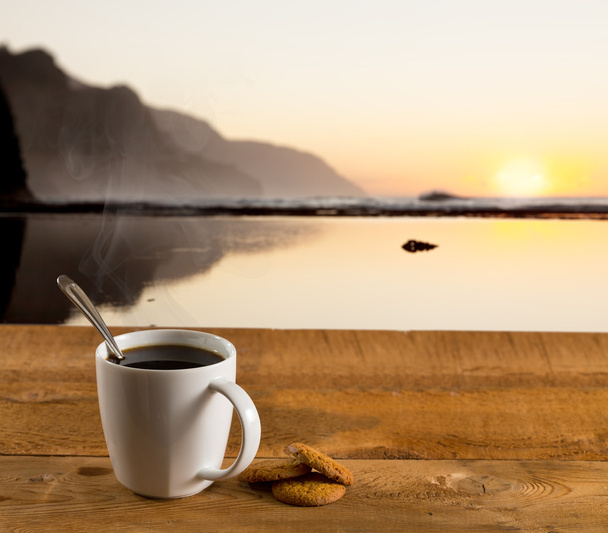 Cup of coffee on wooden table by ocean - Photo, Image