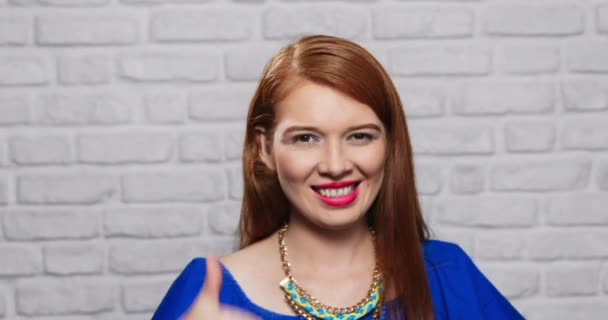 Genç Kızıl saçlı kadının tuğla duvar yüz ifadeleri - Video, Çekim