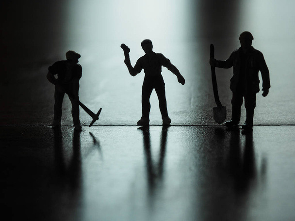 Miniature people silhouette, worker digging on the floor. - Фото, зображення