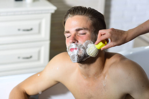 Bearded man getting shaving foam applied on beard with brush - Fotografie, Obrázek