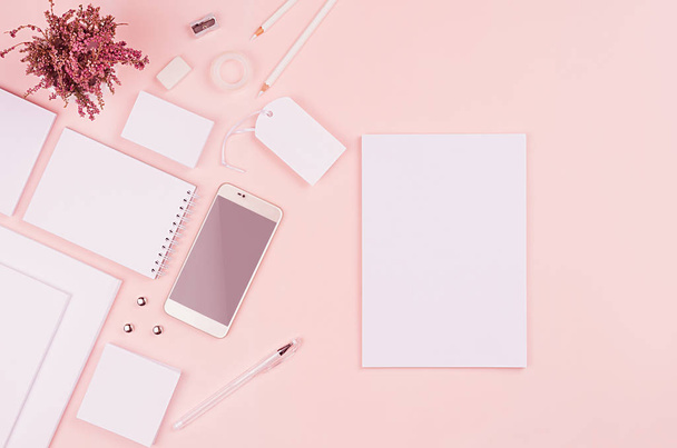 Modern minimalistic spring workspace with white blank stationery on soft pastel pink background, top view, copy space. - Foto, afbeelding