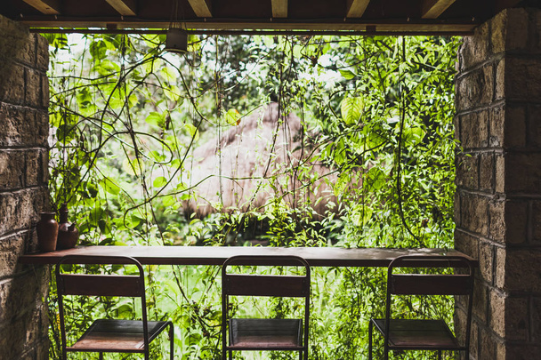 Bar balcão e três cadeiras com vista para o jardim em Bali
 - Foto, Imagem
